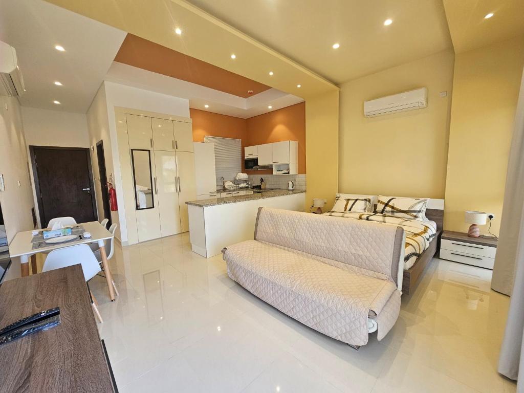 Habitación grande con cama, sofá y cocina. en Hawana Salalah Marina Studio ستوديو في مارينا هوانا صلاله en Salalah