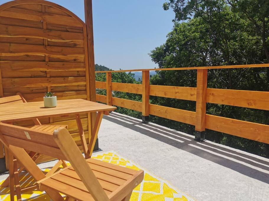 een houten terras met een houten tafel en stoelen bij Appartement de 30m2 pour 2 personnes Venaco in Venaco