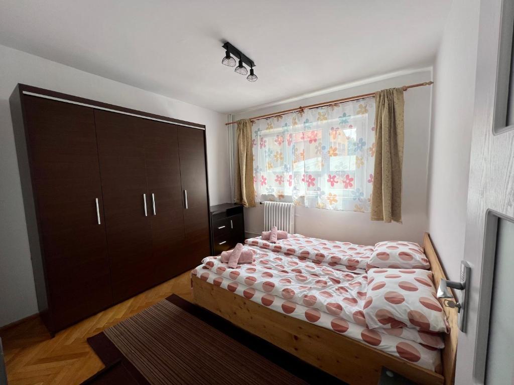 a small bedroom with a bed and a window at Rose City Apartment in Oradea