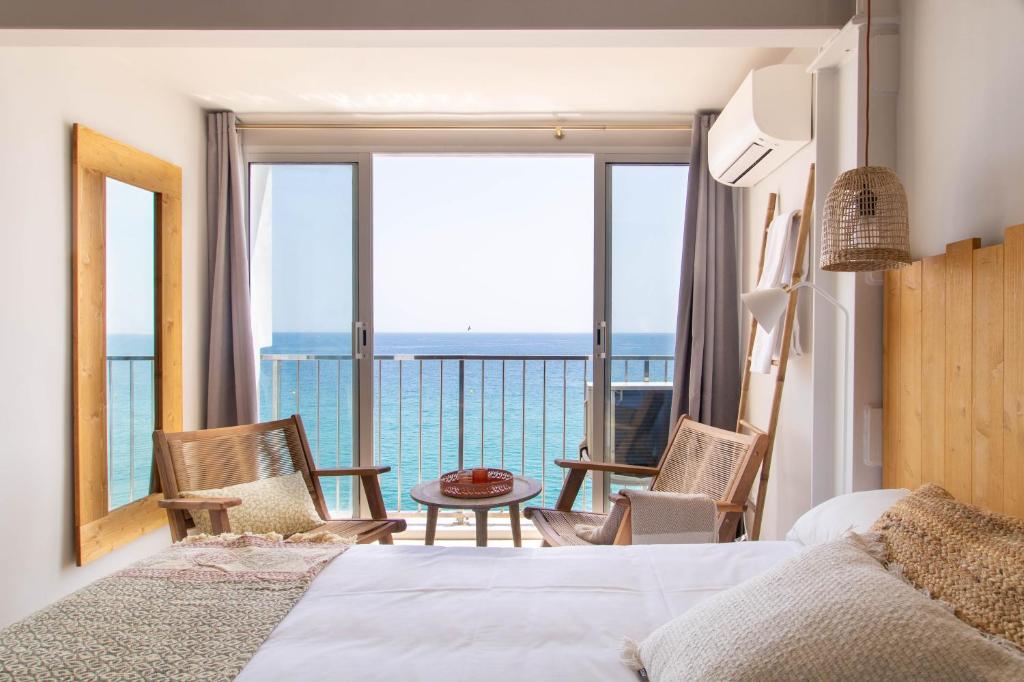 a bedroom with a bed and a view of the ocean at Banana Beach Boutique Studio in Platja  d'Aro