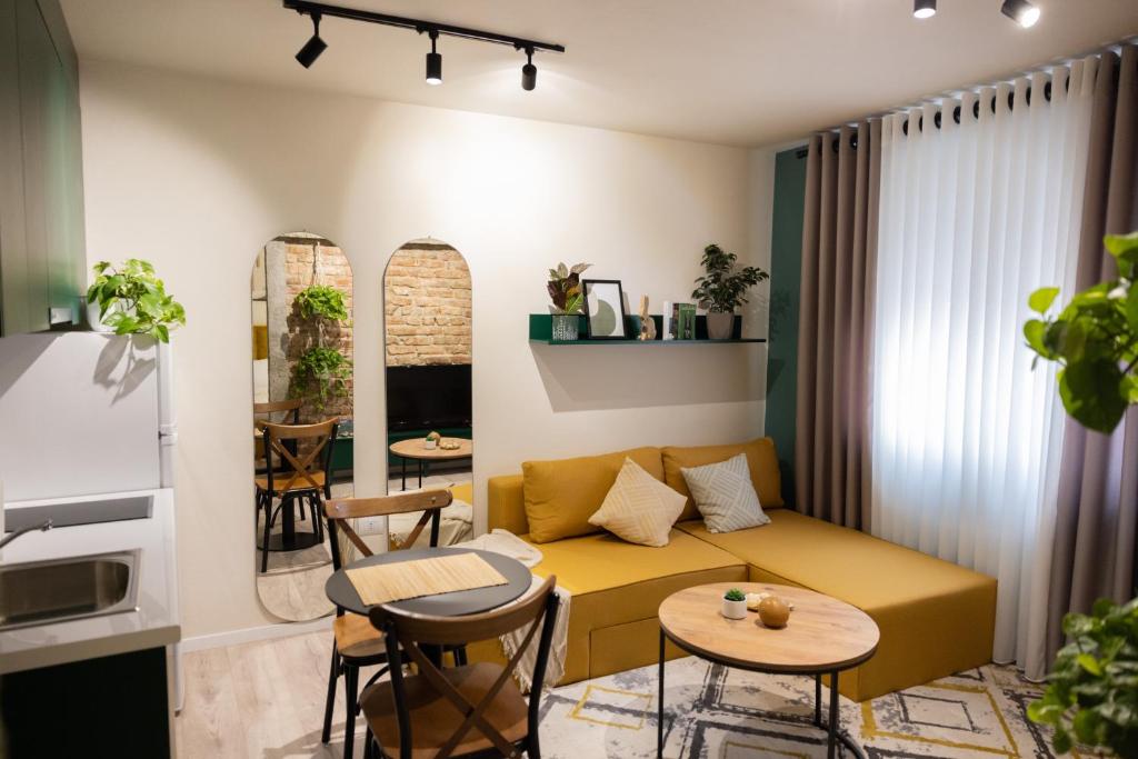 un soggiorno con divano, tavolo e sedie di Three doors apartments, Kiwi 1+1 apartment a Tirana