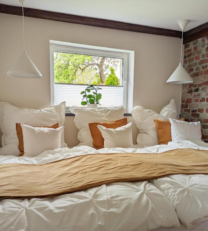 ein großes Bett mit weißen Kissen und einem Fenster in der Unterkunft Ferienhaus Lausitz in Lauta