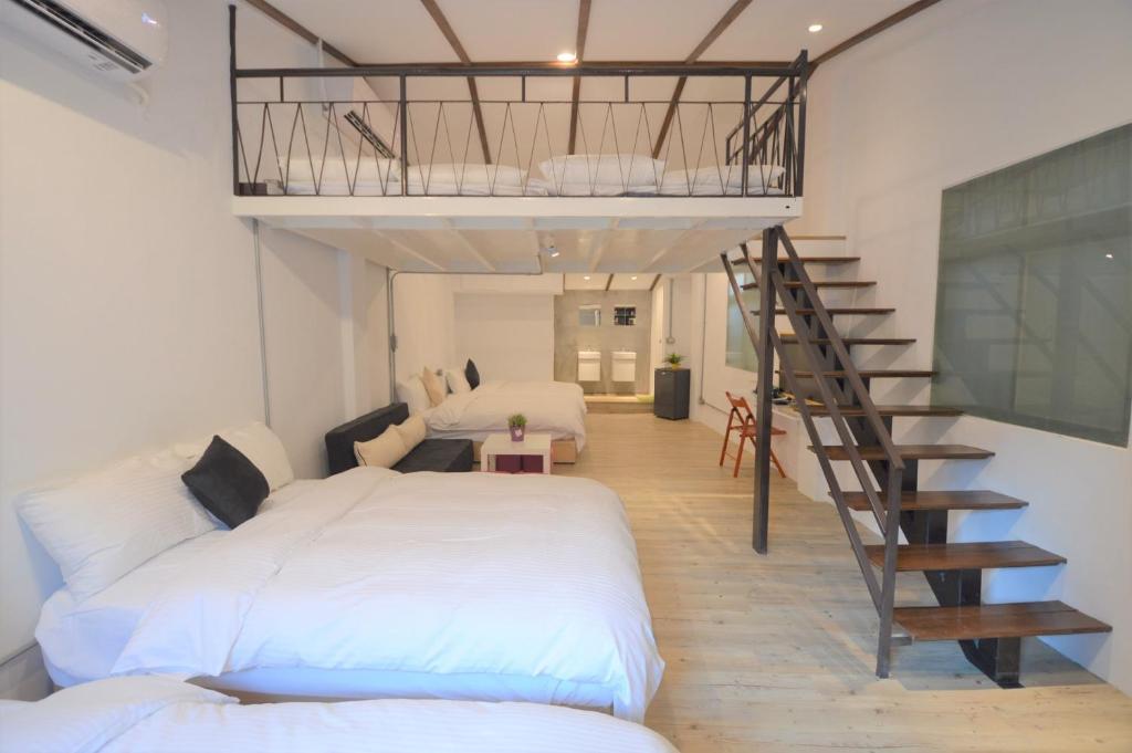 een slaapkamer met een groot bed en een trap bij 小巷微宿 in Taichung
