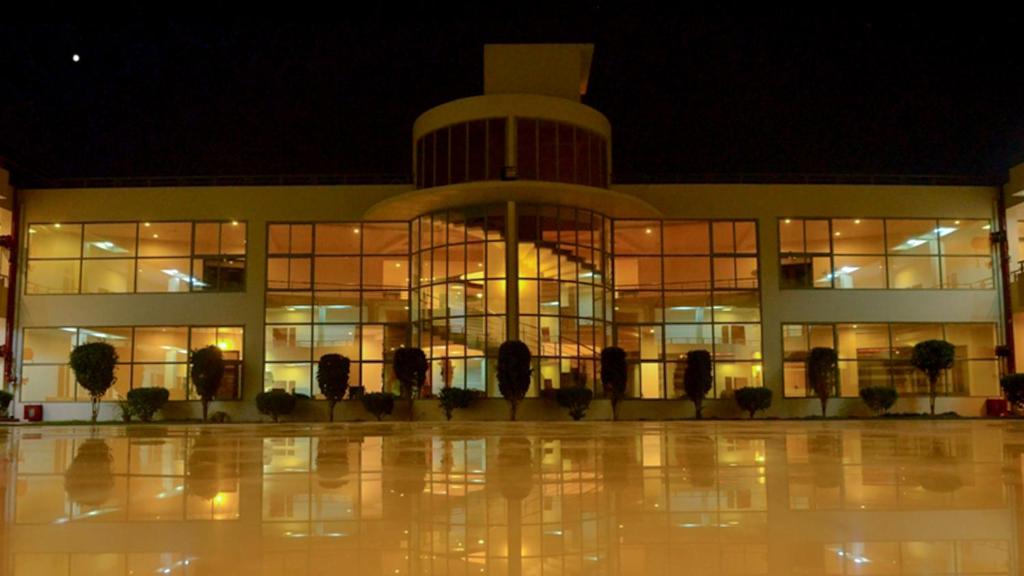 a large building with a lot of windows at night at Seven Sky Clarks Exotica in Bhuj