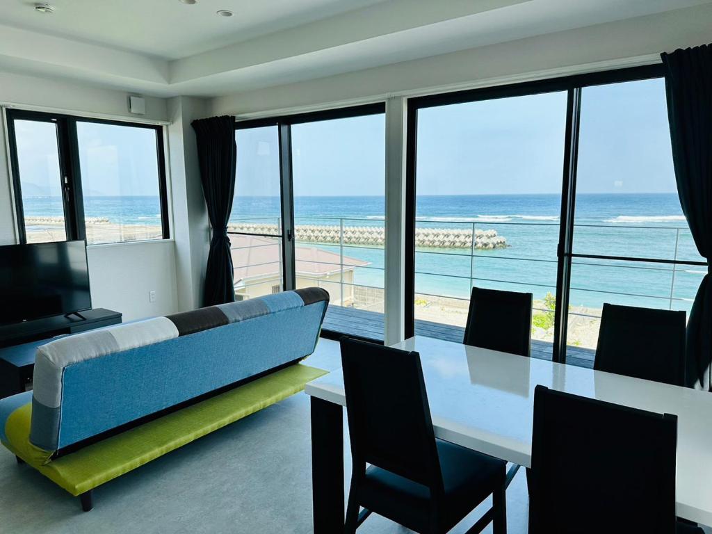 een eetkamer met een tafel en uitzicht op de oceaan bij AZ Hotel Ocean View in Sani