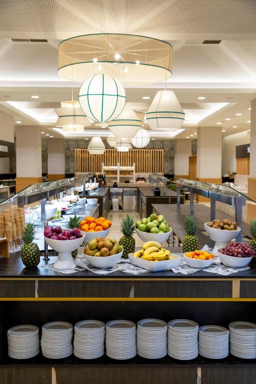 a buffet line with bowls of fruits and vegetables at Puerto Antilla Grand Hotel in Islantilla