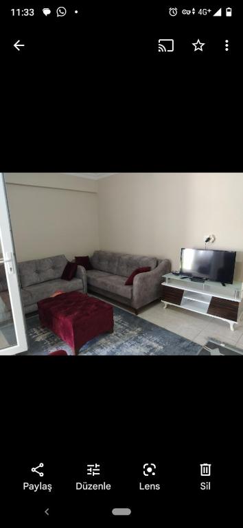 uma sala de estar com um sofá e uma televisão em Avşa kiralık yazlık ev em Marmara