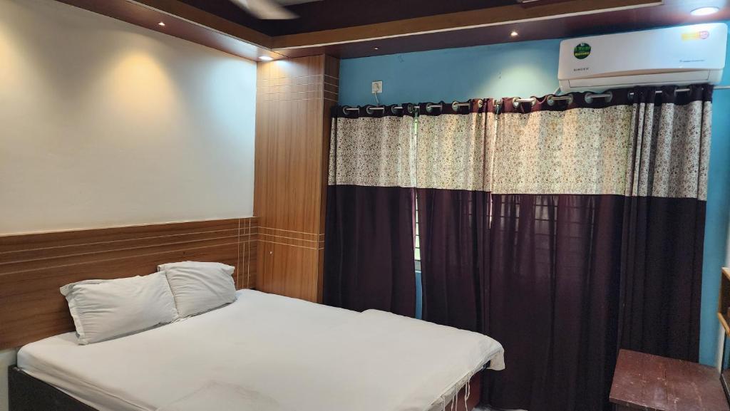 a small bedroom with a bed and a curtain at Dream Palace Resort in Cox's Bazar