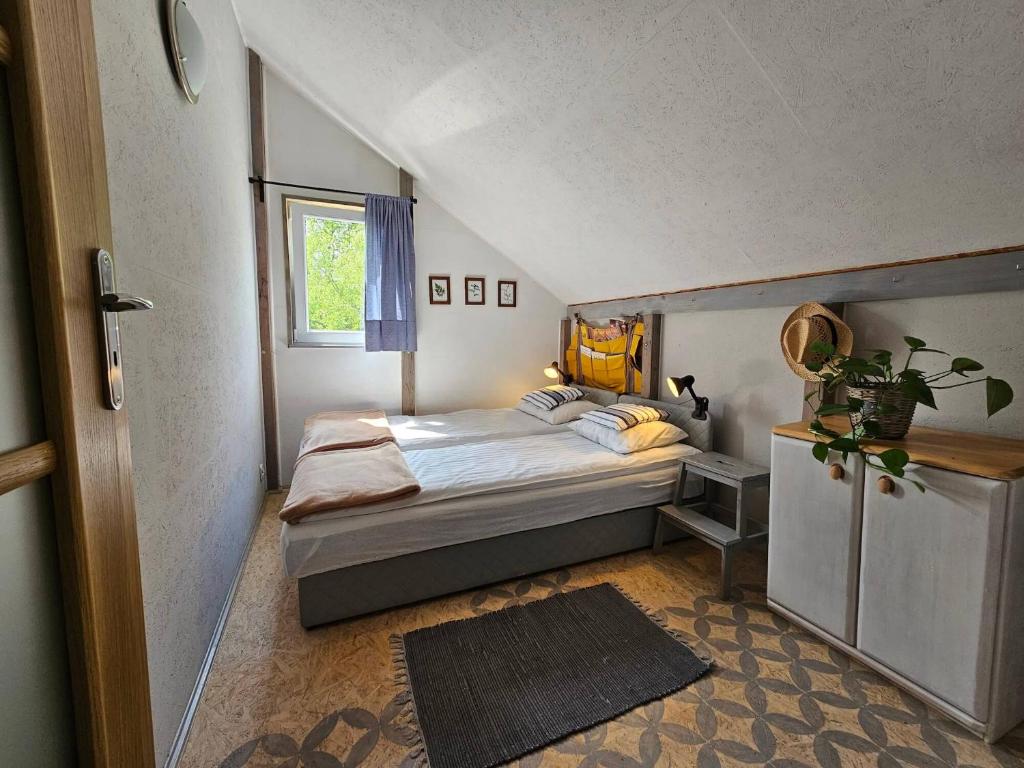 niewielka sypialnia z łóżkiem i oknem w obiekcie Vitalny Domek z ogrodem nad jeziorem, 10 min od Mrągowa w mieście Ruska Wieś