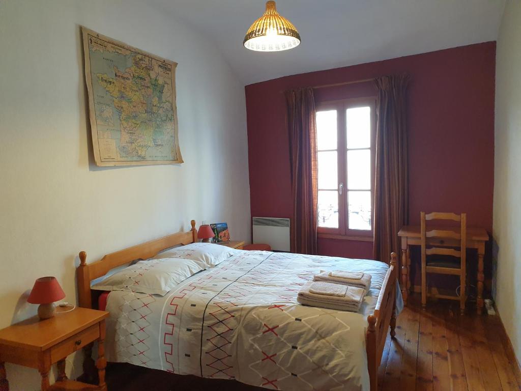 - une chambre avec un lit, une table et une fenêtre dans l'établissement Le logis de la tour, à Avignon