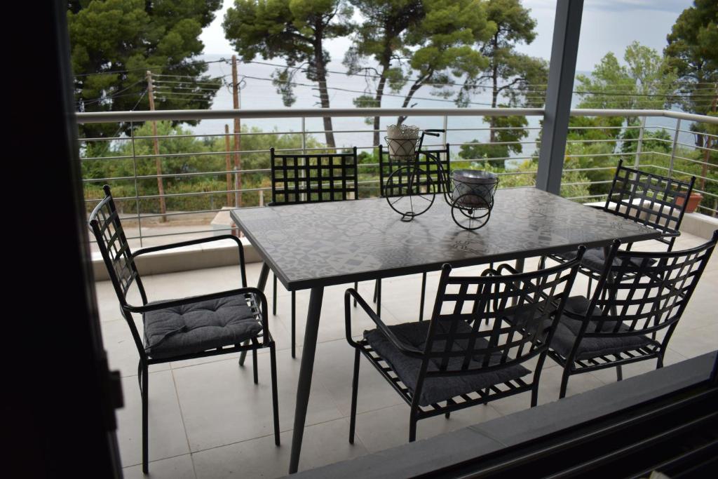 a table and chairs on a balcony with a view at Mathesi Beachfront Apartment in Elia in Elia