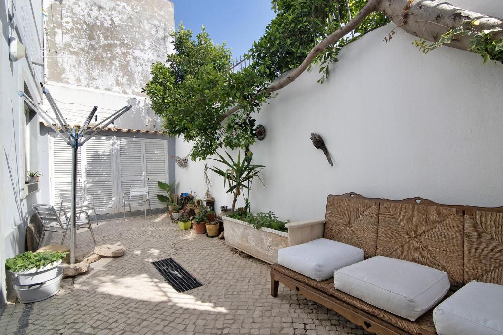 a patio with a couch and trees and plants at Casa da Cidade de Loulé in Loulé