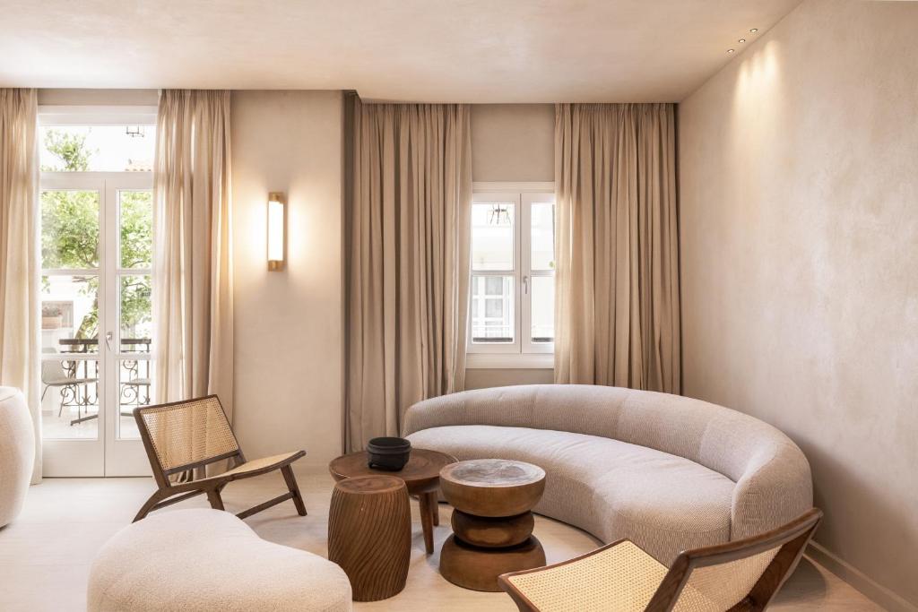 a living room with a couch and a table and chairs at Doryssa Theorem Hotel in Pythagoreio