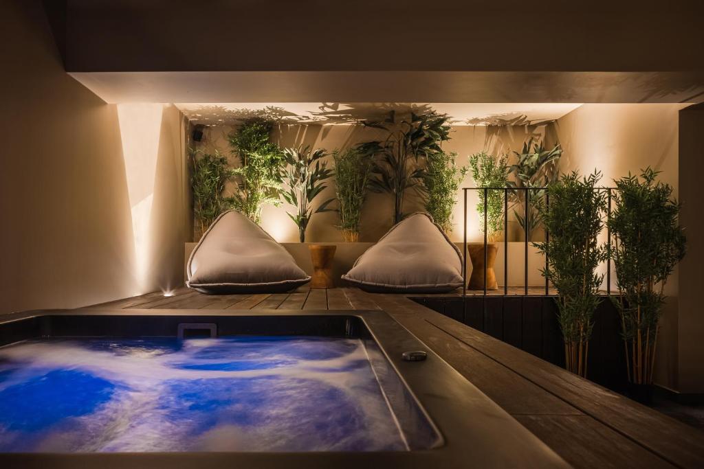 a hot tub in a room with potted plants at Doryssa Theorem Hotel in Pythagoreio