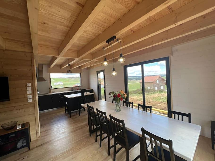une grande salle à manger avec une grande table et des chaises dans l'établissement Le Gite des Genêts, à Coucouron