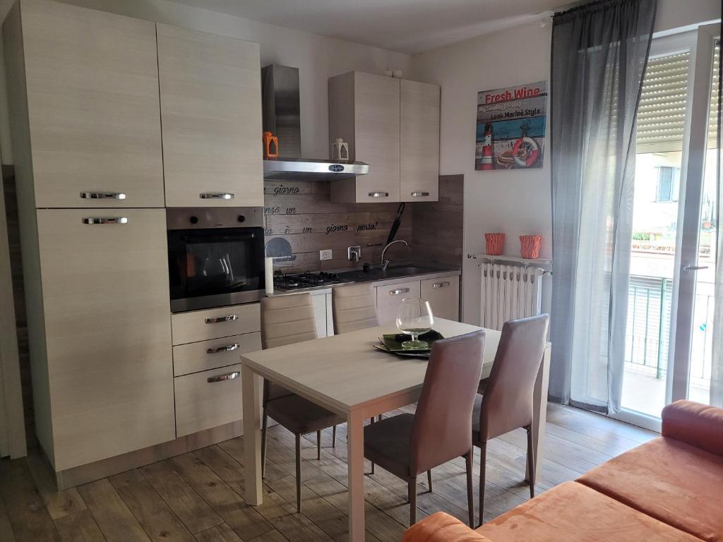 a kitchen with a table and chairs and a kitchen with white cabinets at Casa Dany in Albissola Marina