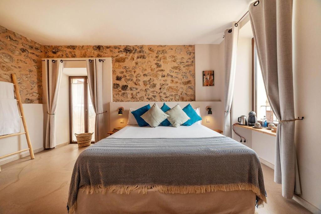 a bedroom with a large bed with blue pillows at Ōrigins Hotel Boutique - Adults Only in Artá