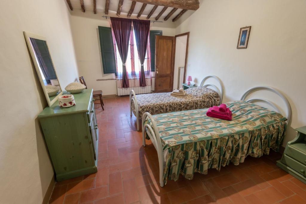 a room with two beds and a table and a window at ROSMARINO in Città della Pieve