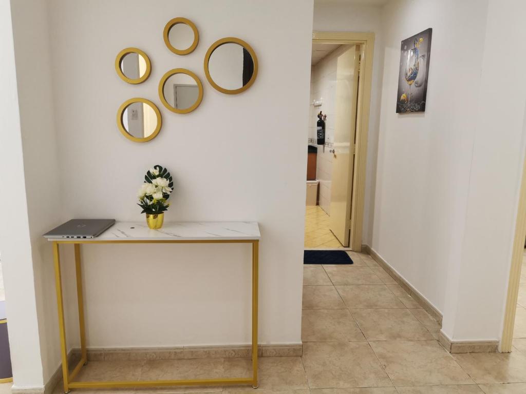 un pasillo con una mesa y espejos en la pared en Better Homes en Sharjah