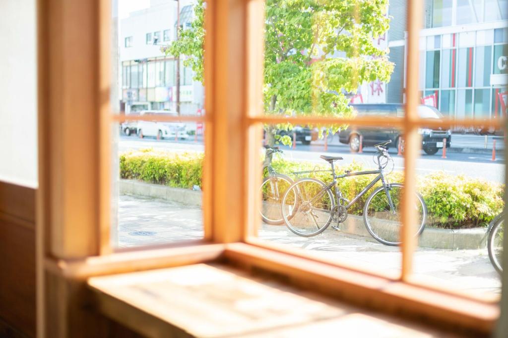 a window with two bikes parked on a street at Charlie's Bed in Wakayama