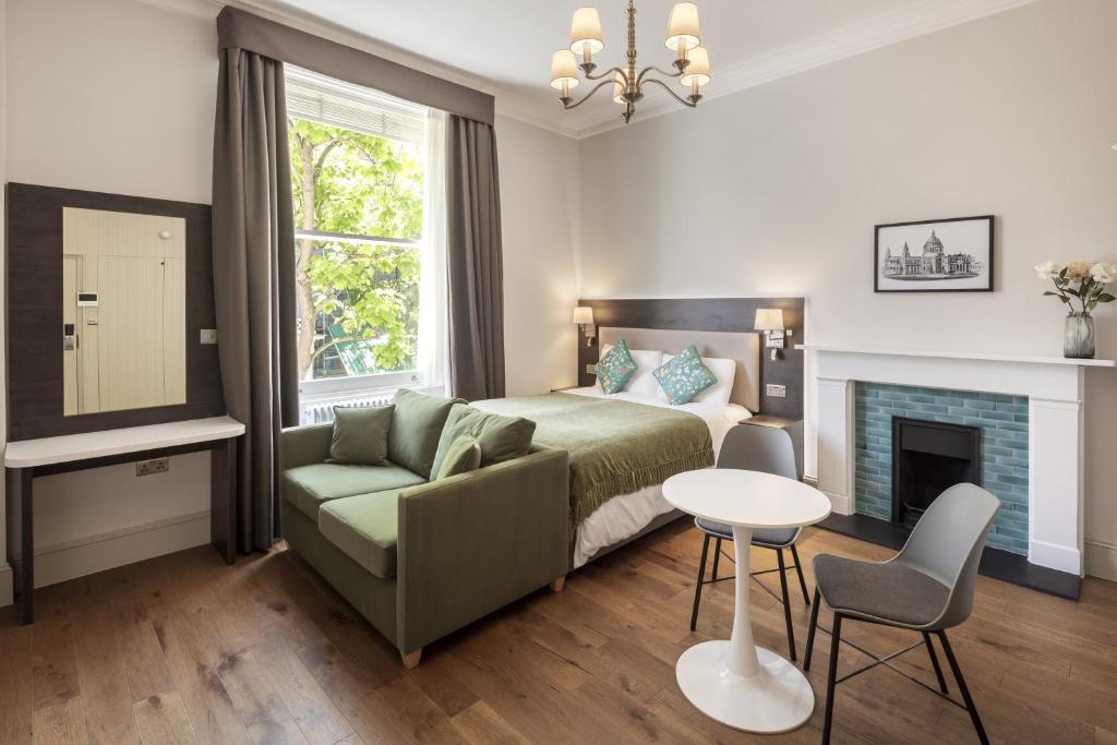 a bedroom with a bed and a couch and a table at Notting Hill House in London