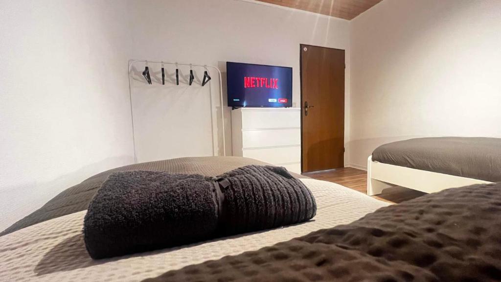 sypialnia z dwoma łóżkami i telewizorem na ścianie w obiekcie Chic Apartments - Smart-TVs w mieście Stemshorn