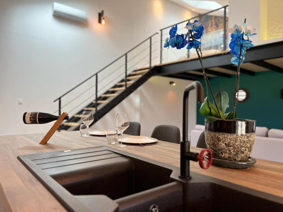 a kitchen with a sink and a table with a wine glass at Loft design in Lapalud