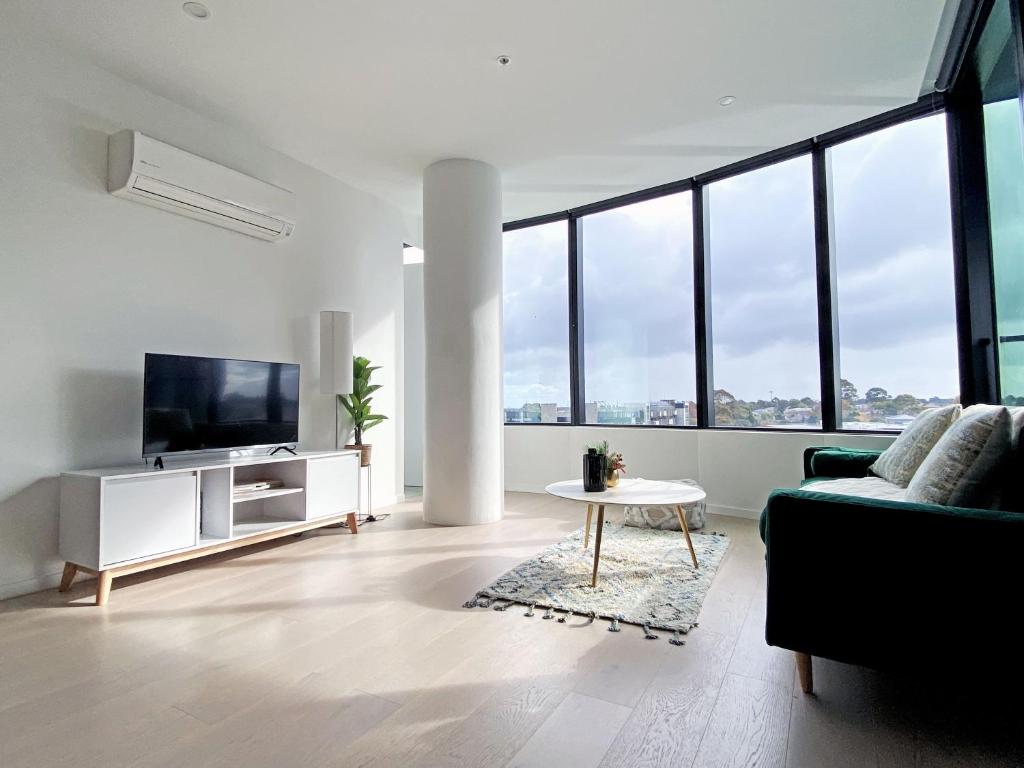 a living room with a couch and a tv at Skygarden Luxury Condo in Glen Waverley