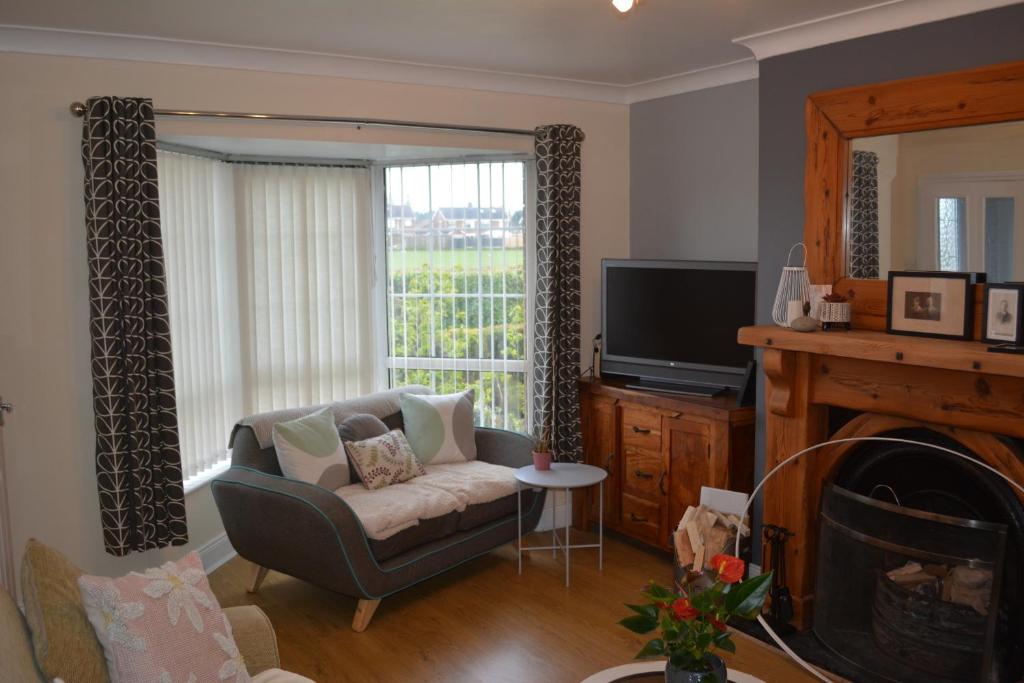 a living room with a chair and a television at 2 Barbour Court in Lisburn
