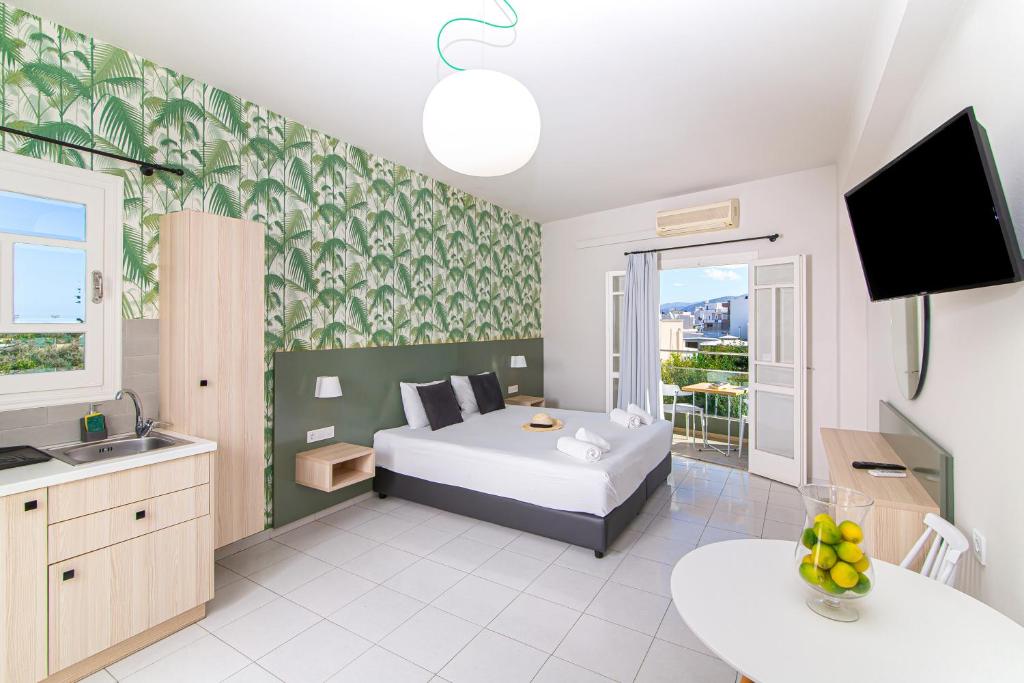 um quarto com uma cama, um lavatório e uma televisão em Sunshine Studios em Mália