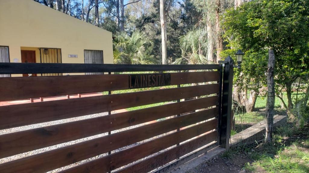 ein Holzzaun mit einem Schild, das die Einfahrt liest in der Unterkunft LA INESITA in Santa Ana