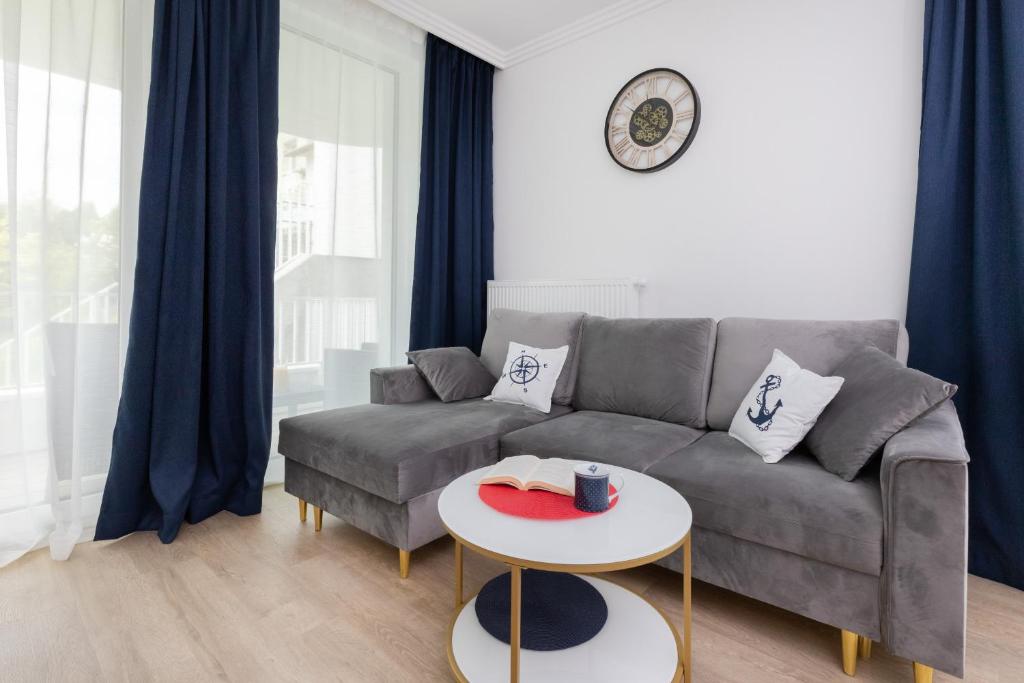 salon z kanapą i stołem w obiekcie Apartment Redlowo & 2 bedrooms & Parking by Renters w mieście Gdynia