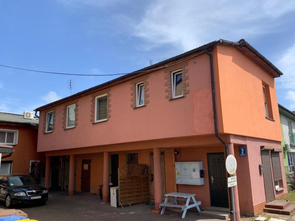 an orange building with a car parked in front of it at Pokoje U Hanki in Dziwnów