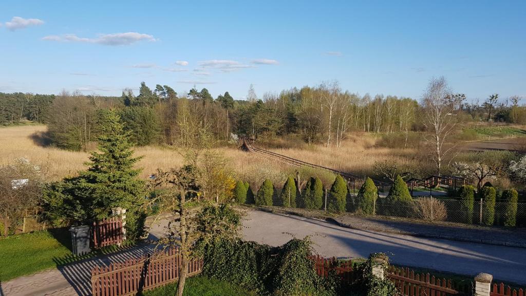 a view of a driveway with a fence and trees at Apartamenty Łąkowa Piecki in Piecki