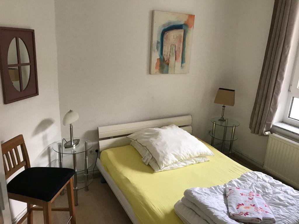 ein Schlafzimmer mit einem Bett, einem Tisch und einem Stuhl in der Unterkunft Möbiliertes wohnen auf dem Sandberg in Flensburg