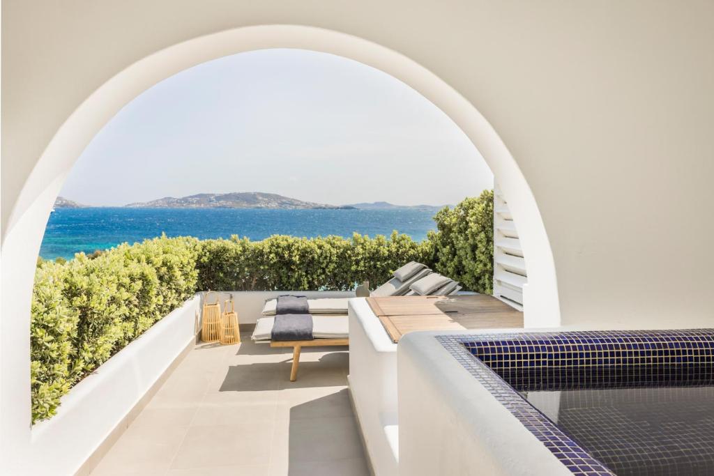 an arched balcony with a view of the ocean at Grace Mykonos in Agios Stefanos