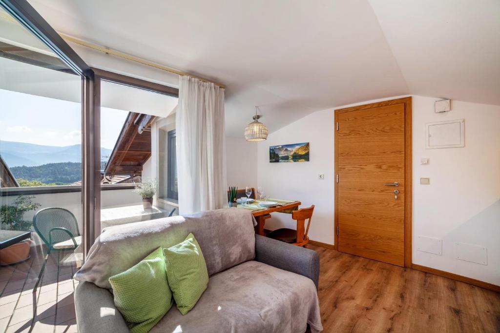 a living room with a couch and a table and a window at Residence Alpina Comfort Nr 7 in Tesimo