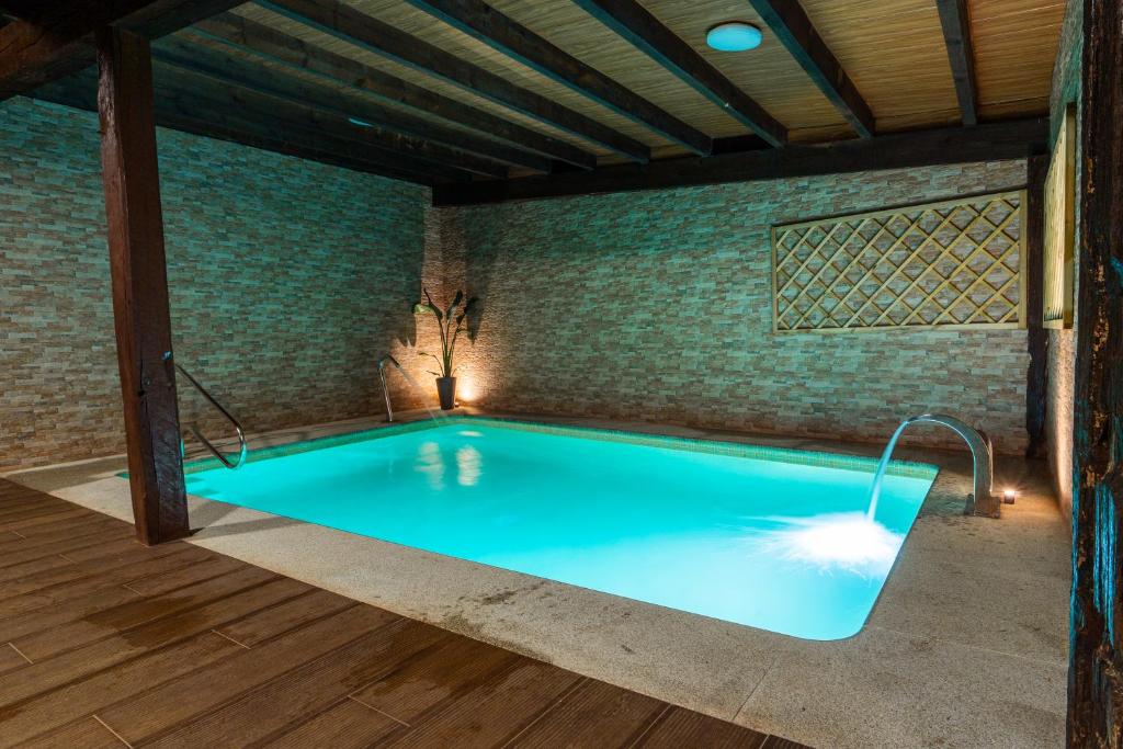 an indoor swimming pool with a brick wall at Albergue GBC Caldas in Caldas de Reis