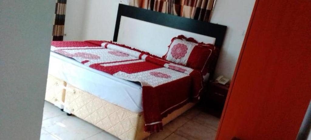 - un lit rouge et blanc dans une chambre dans l'établissement SILVER HOTEL APARTMENT Near Kigali Convention Center 10 minutes, à Kigali