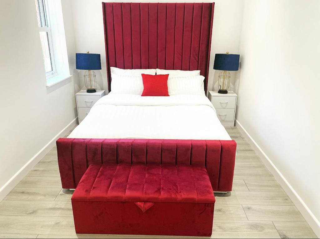 ein rotes Bett mit einer roten Bank in einem Zimmer in der Unterkunft The Lincoln Apartment 2023 NEW-BUILD in Oxford