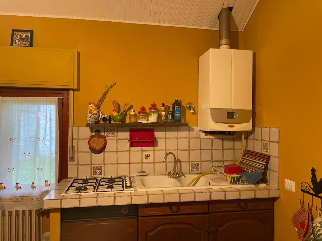 a kitchen with a sink and a stove top oven at La finestra sul castello in Sestola