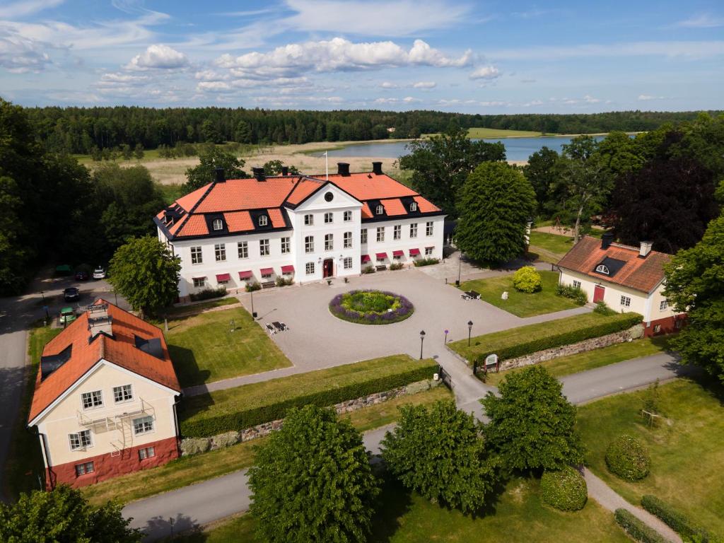 uma vista aérea de um grande edifício branco com um telhado laranja em Stjärnholmsslott em Nyköping