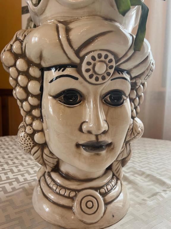 a vase with a face on it sitting on a table at Salemi BnB in Salemi