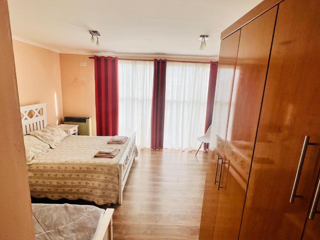 um quarto com uma cama e uma cómoda e cortinas em Duplex Zona Céntrica em Río Gallegos
