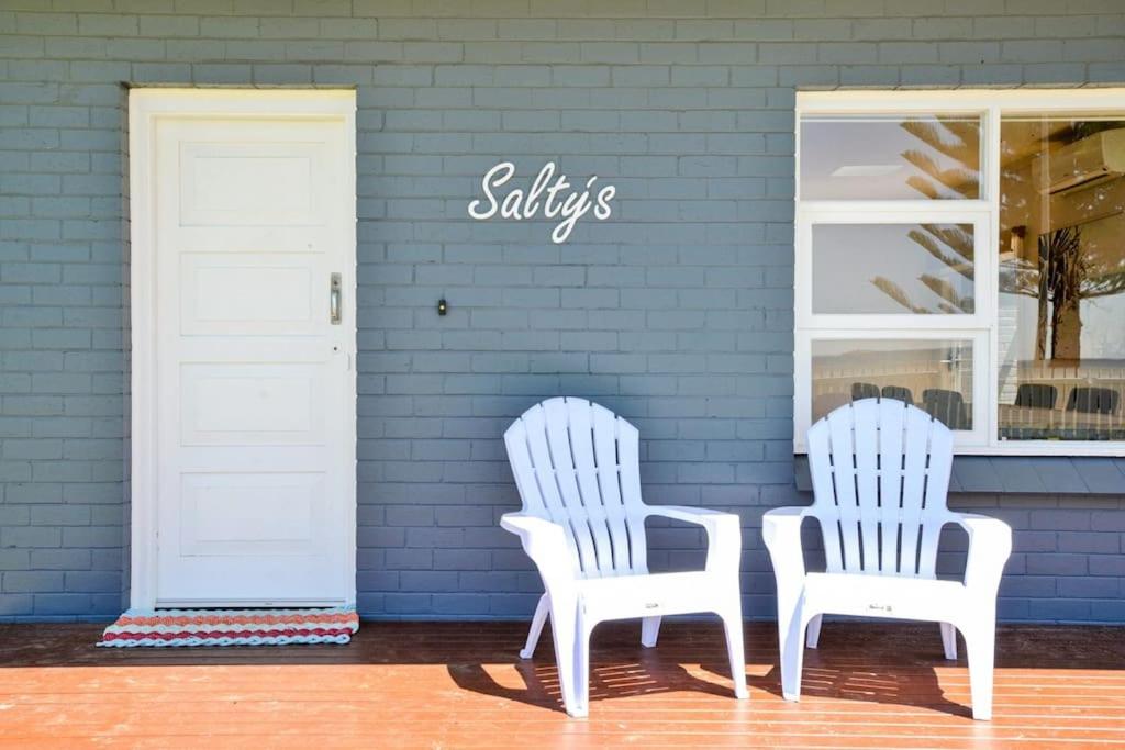 two white chairs sitting in front of a store at Saltys 4BRM Beachfront WIFI Pet Friendly in Victor Harbor