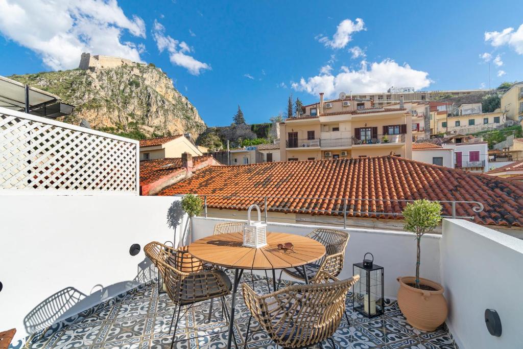 a patio with a table and chairs on a roof at Kastro Residence in Nafplio