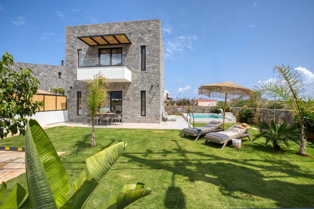 a large stone house with a yard with benches at Hermagio Villa Hermione by Estia in Malia