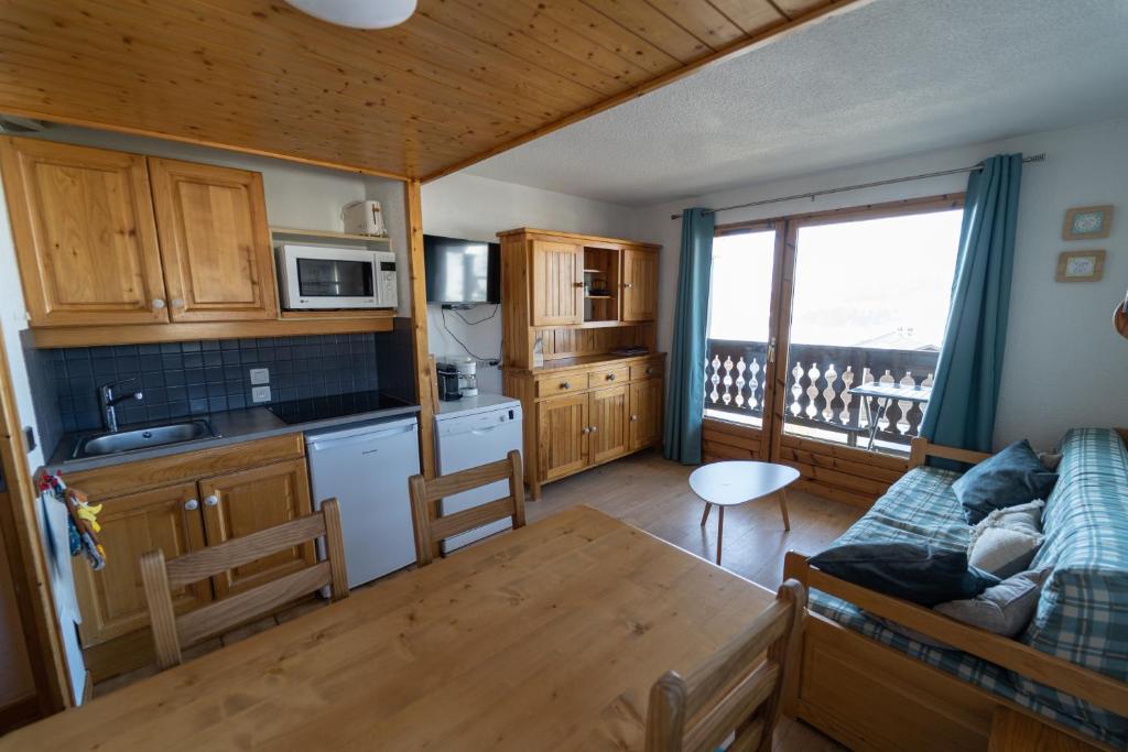 a kitchen and living room with a couch and a table at Les Saisies appart 1 chambre au pied des pistes in Les Saisies