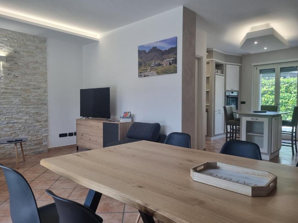 uma sala de estar com uma mesa de madeira e cadeiras em Suite vacanze Chabloz nel cuore della Valle d'Aosta em Nus