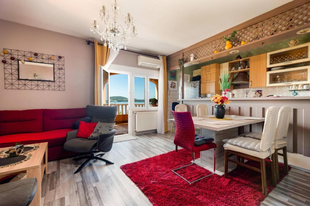 Apartment Lotus في تروغير: غرفة معيشة مع أريكة حمراء وطاولة